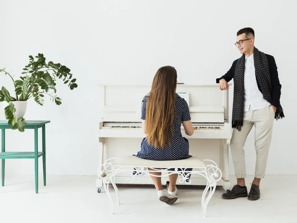 Musician standing beside a pianist during a rehearsal